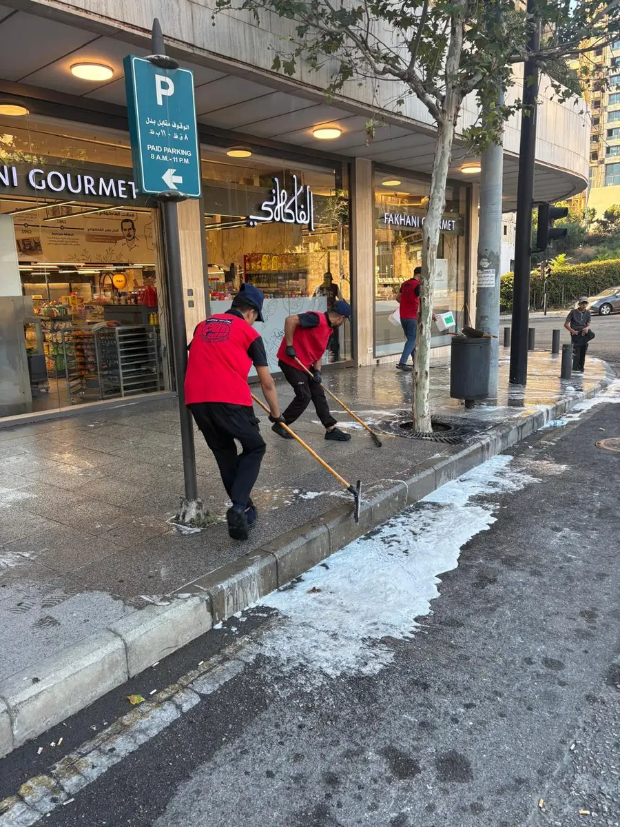 Sweeping the sidewalk outside a restaurant
