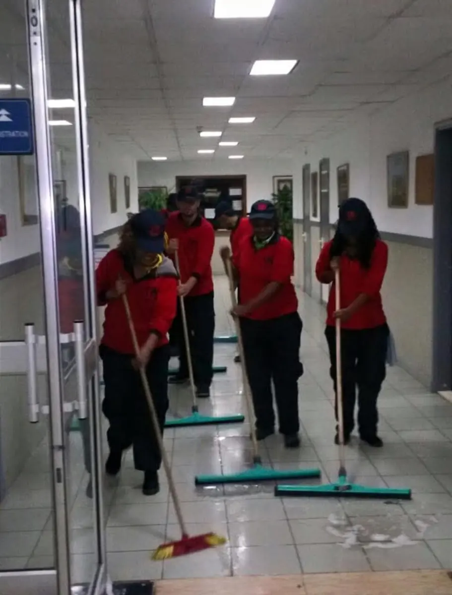 Team mopping a school corridor